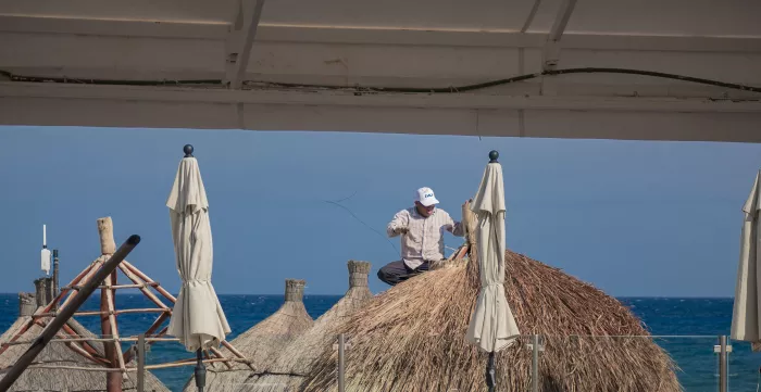 A man repairs a parasol in extreme heat in the Yucatán peninsula, Mexico