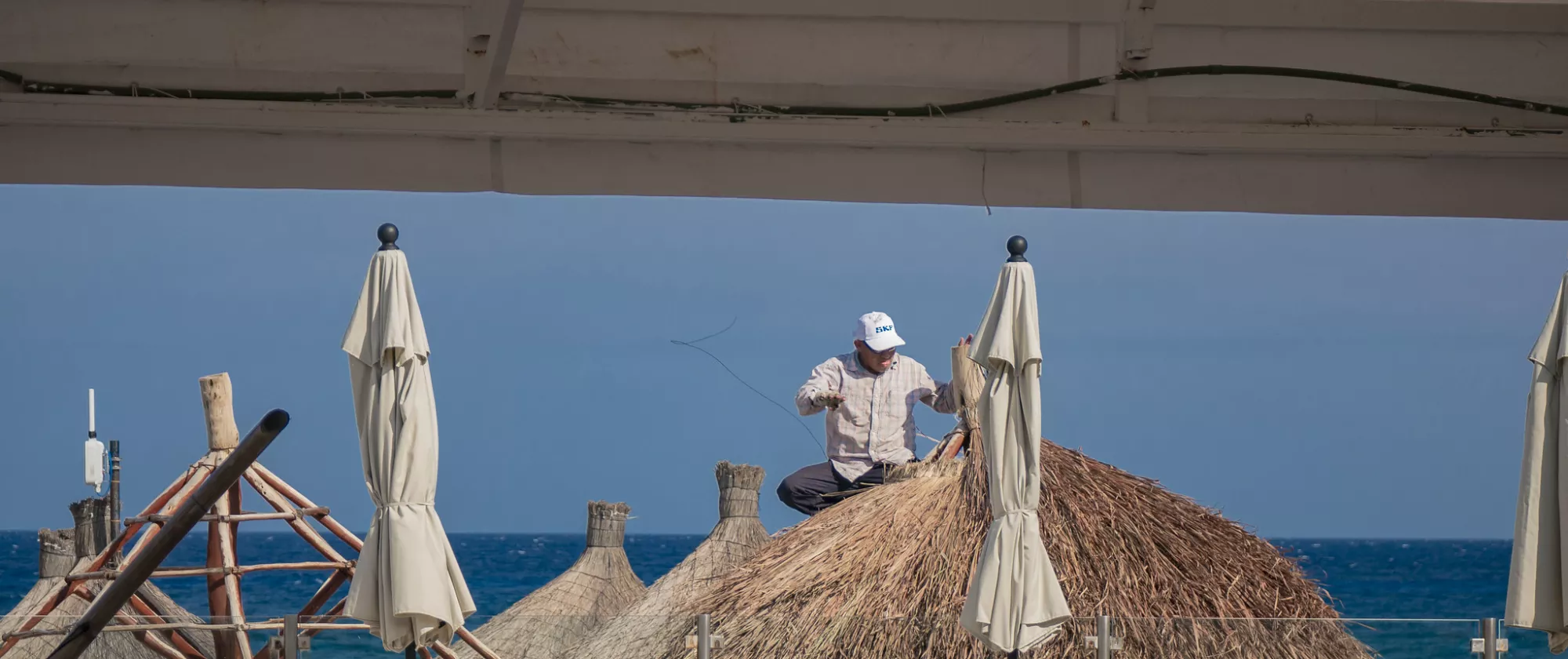 A man repairs a parasol in extreme heat in the Yucatán peninsula, Mexico