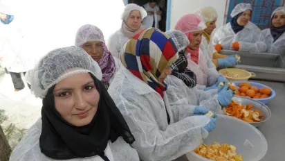 Female workers in Tunisia are processing mandarins.