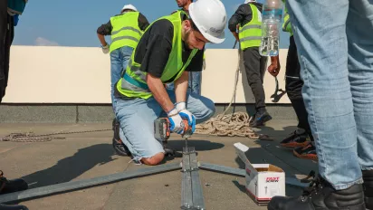 workers installing solar panels on a roof