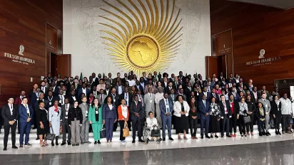 Delegates stand in a hall inside the African Union building and sign for a group picture