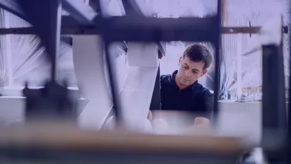 Worker using a machine in a factory