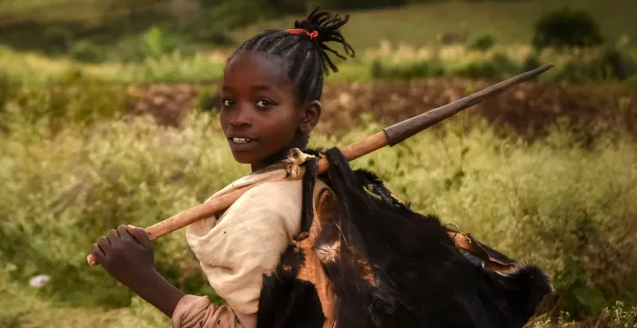 Young African girl carrying a load on her back in Ethiopia